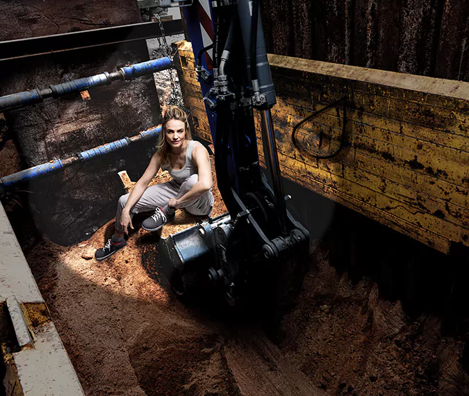 eine Frau sitzt auf Sand auf einer Baustelle